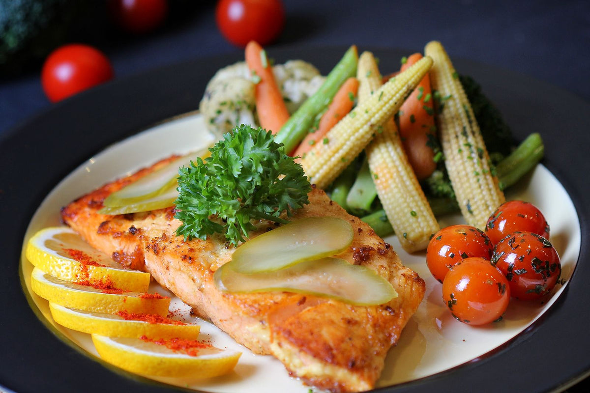 Baked salmon with lemon, cherry tomatoes and vegetables on a plate