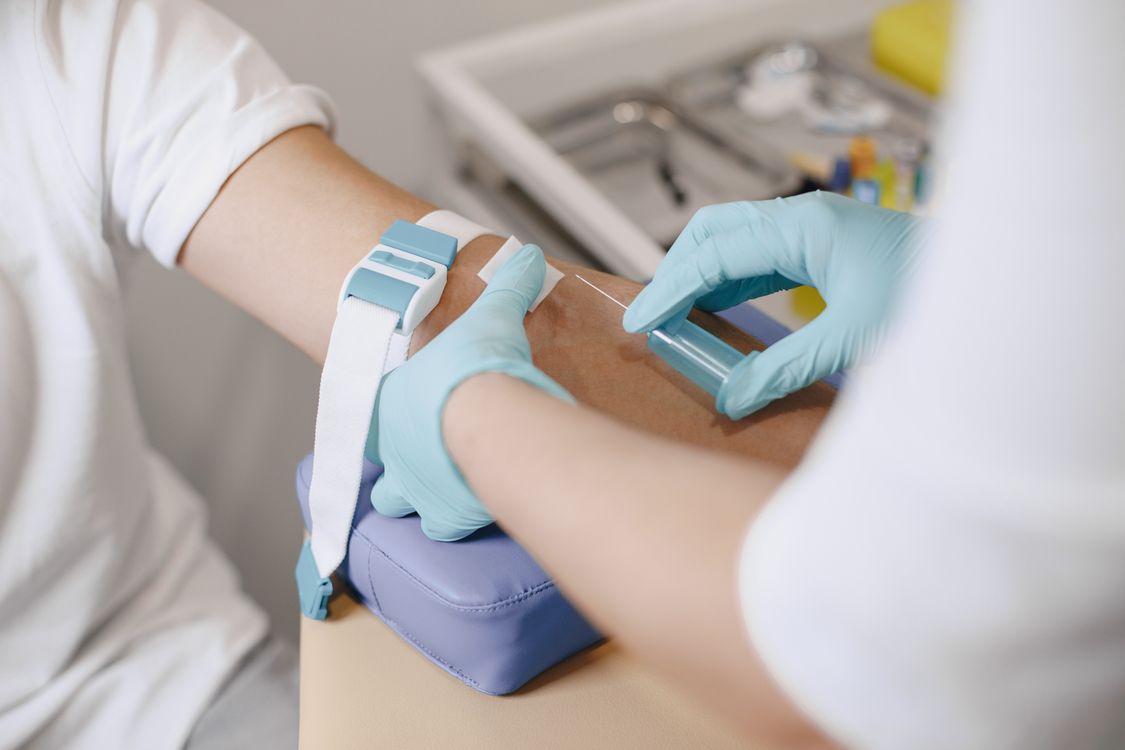A healthcare professional drawing blood from a patient's arm for laboratory testing